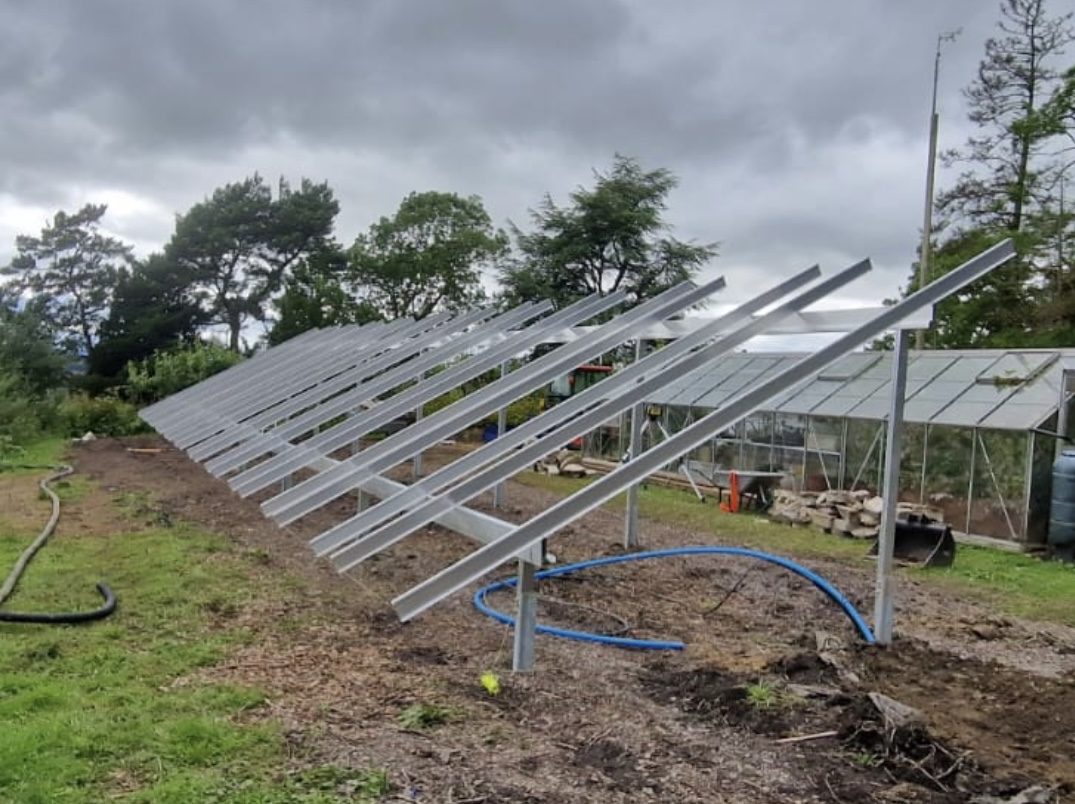 The bare steel mounting frame during construction, under a heavy sky